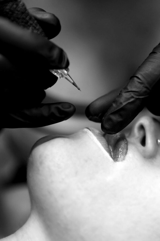 Hero image. Cosmetic needle approaching lips.